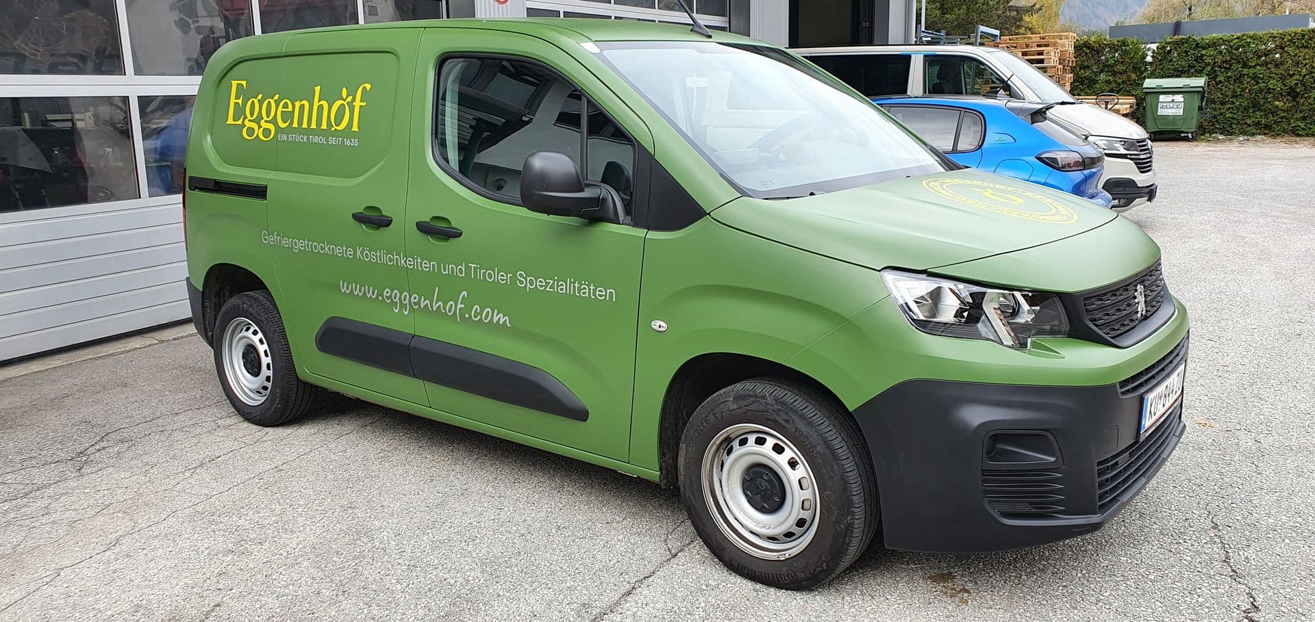 Grüner Peugeot Partner mit Beschriftung eines Tiroler Spezialitätenbetriebs