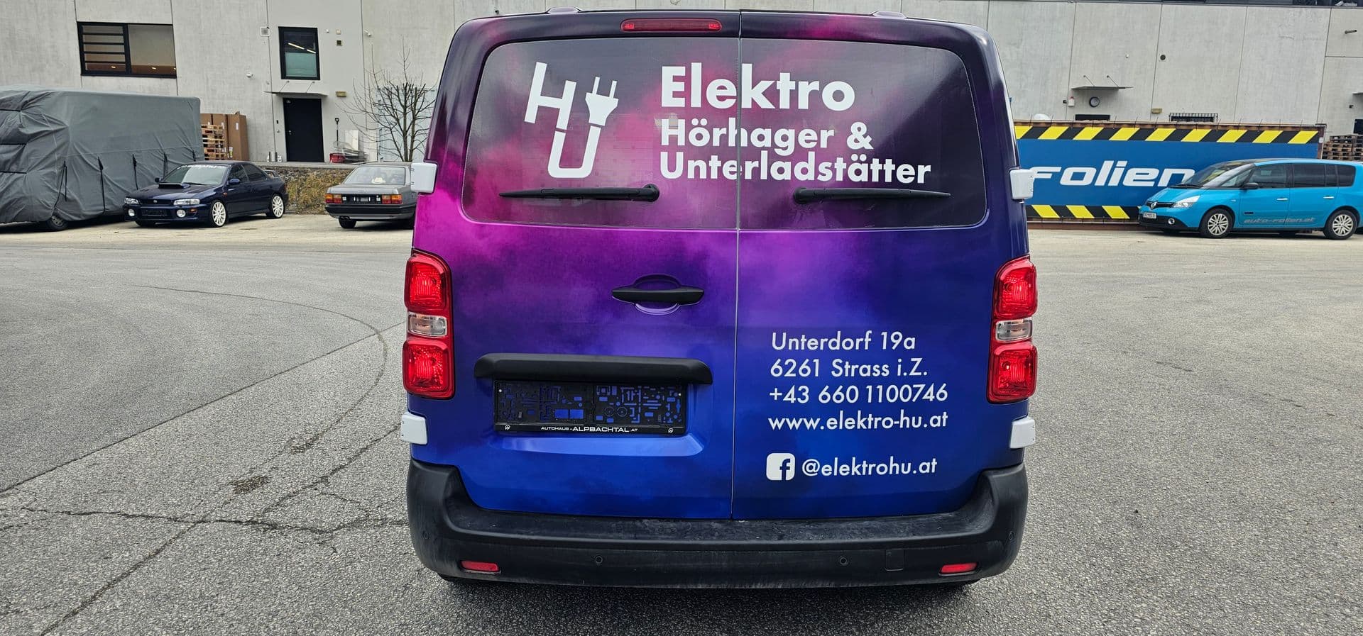 Heck eines Transporters mit violett-blauem Farbverlauf im Digitaldruck und Kontaktdaten eines Elektrobetriebs