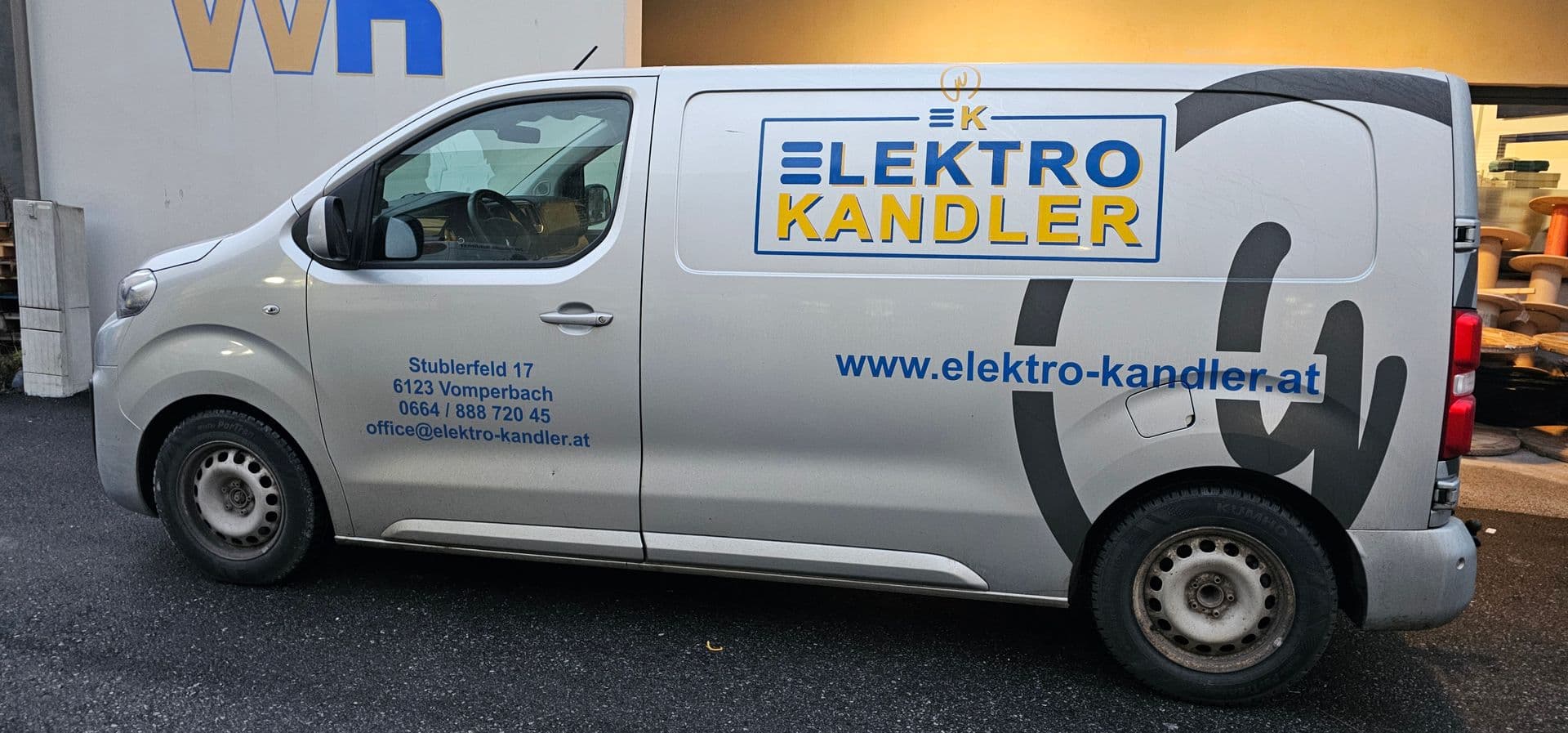 Silberner Peugeot Expert mit blau-gelbem Logo und Kontaktdaten eines Elektrobetriebs