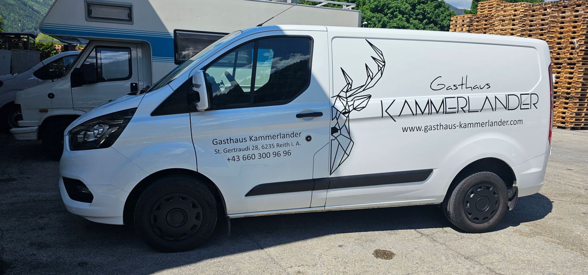 Weißer Ford Transit Custom mit fein gezeichnetem Hirschkopf in Linienoptik und Beschriftung eines Gasthauses