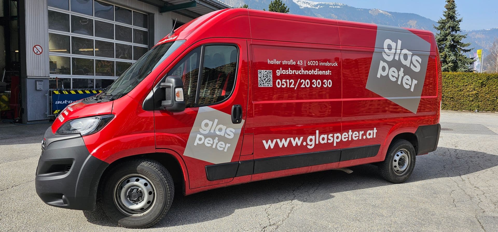 Roter Fiat Ducato Kastenwagen mit großflächiger Beschriftung eines Innsbrucker Glasereibetriebs