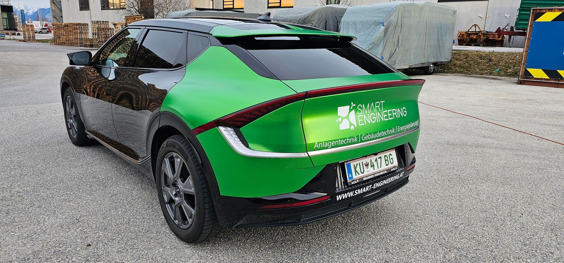 Kia EV6 zweifarbig in Grün und Schwarz foliert, mit Logo und Leistungsübersicht eines Anlagentechnikbetriebs