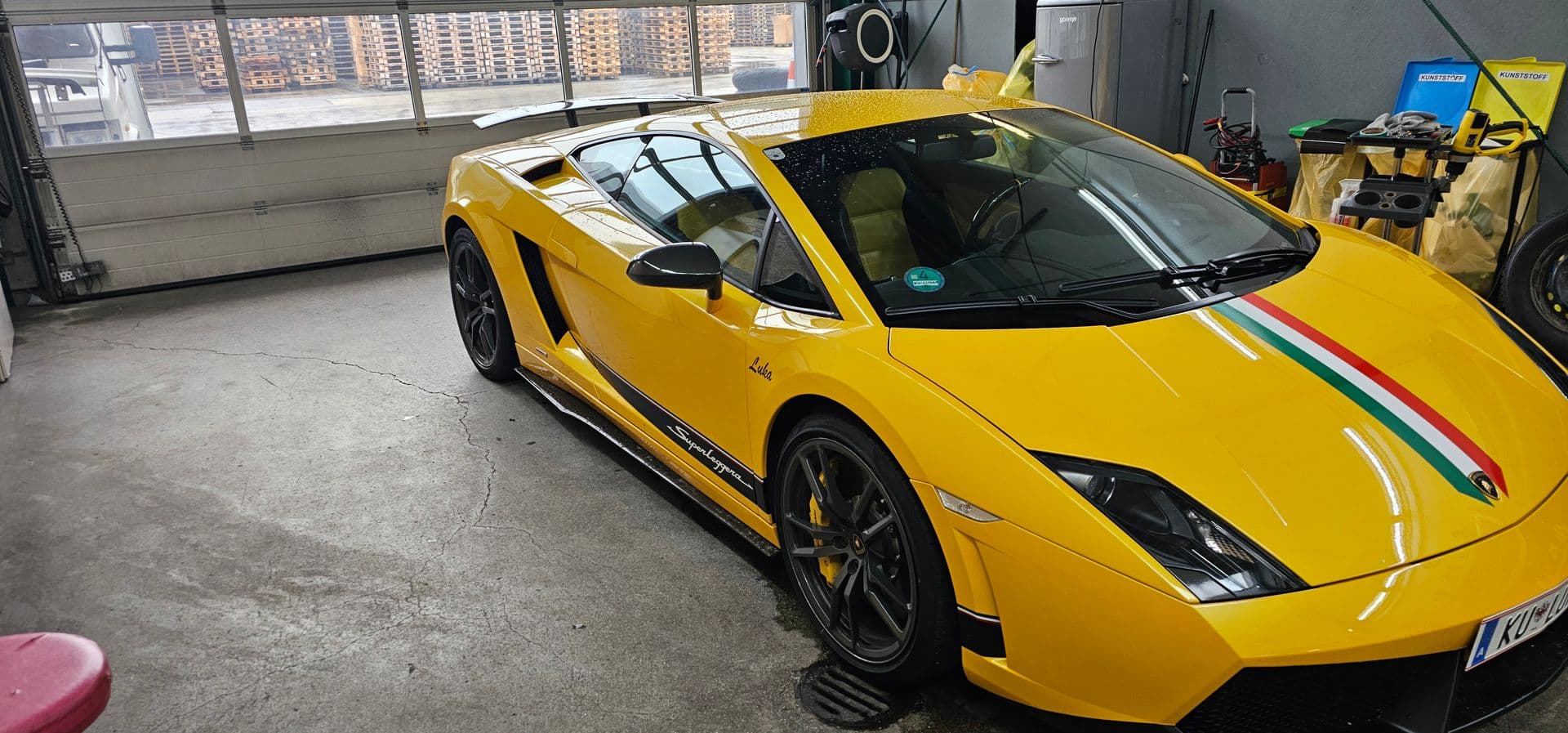 Gelber Lamborghini Gallardo Superleggera mit grün-weiß-rotem Streifen über der Fronthaube, in der Werkstatt von auto-folien.at