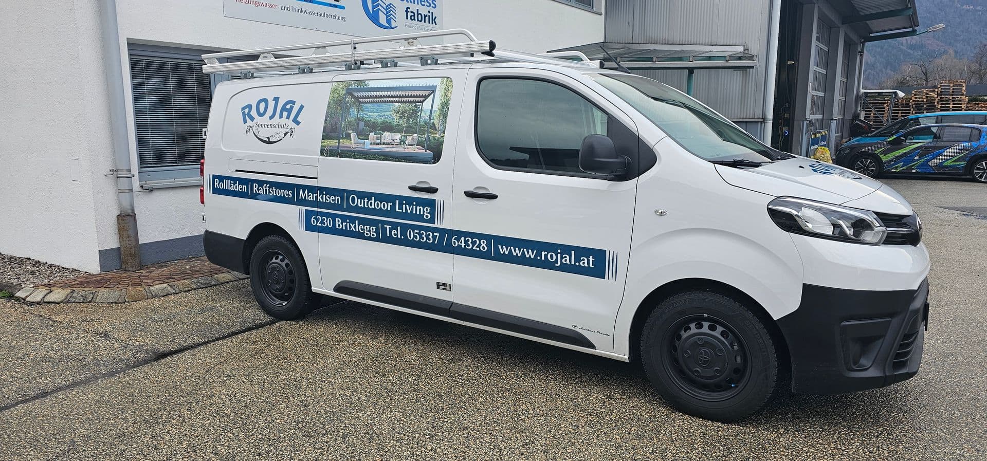 Weißer Toyota Proace mit blauer Beschriftung eines Brixlegger Sonnenschutzbetriebs, Frontansicht