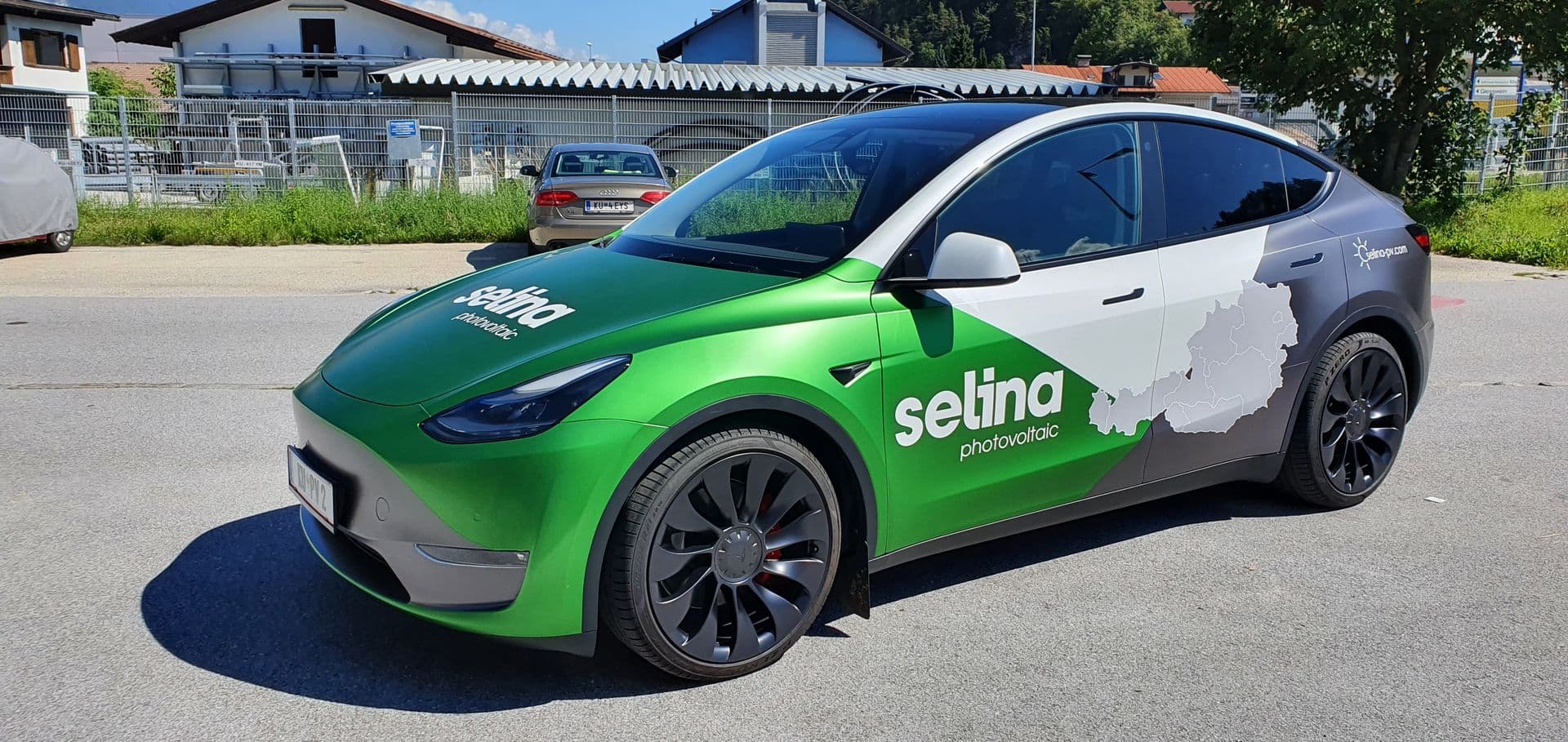Tesla Model Y mit grün-weißer Beschriftung eines Photovoltaikbetriebs, Frontansicht